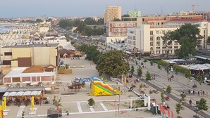 A public square with a large inflatable slide, seating areas, and a view of the cityscape in the background. - The Premier Studio (Constanta)