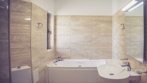 Un baño con una bañera, un lavabo y un espejo.