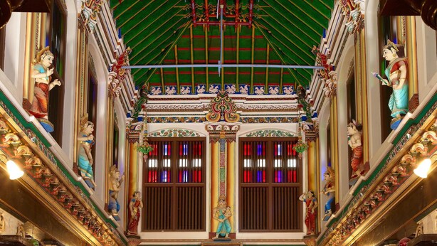 An ornate hall with high ceilings, detailed carvings, and a central dining area with tables set for a meal. - Chidambara Vilas - A Luxury Heritage Resort (Thirumayam)