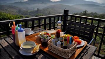 A picnic setup on a wooden deck with a scenic mountain view in the background.