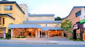 Un hotel de diseño moderno, con una entrada amplia y una zona de estar exterior cubierta.