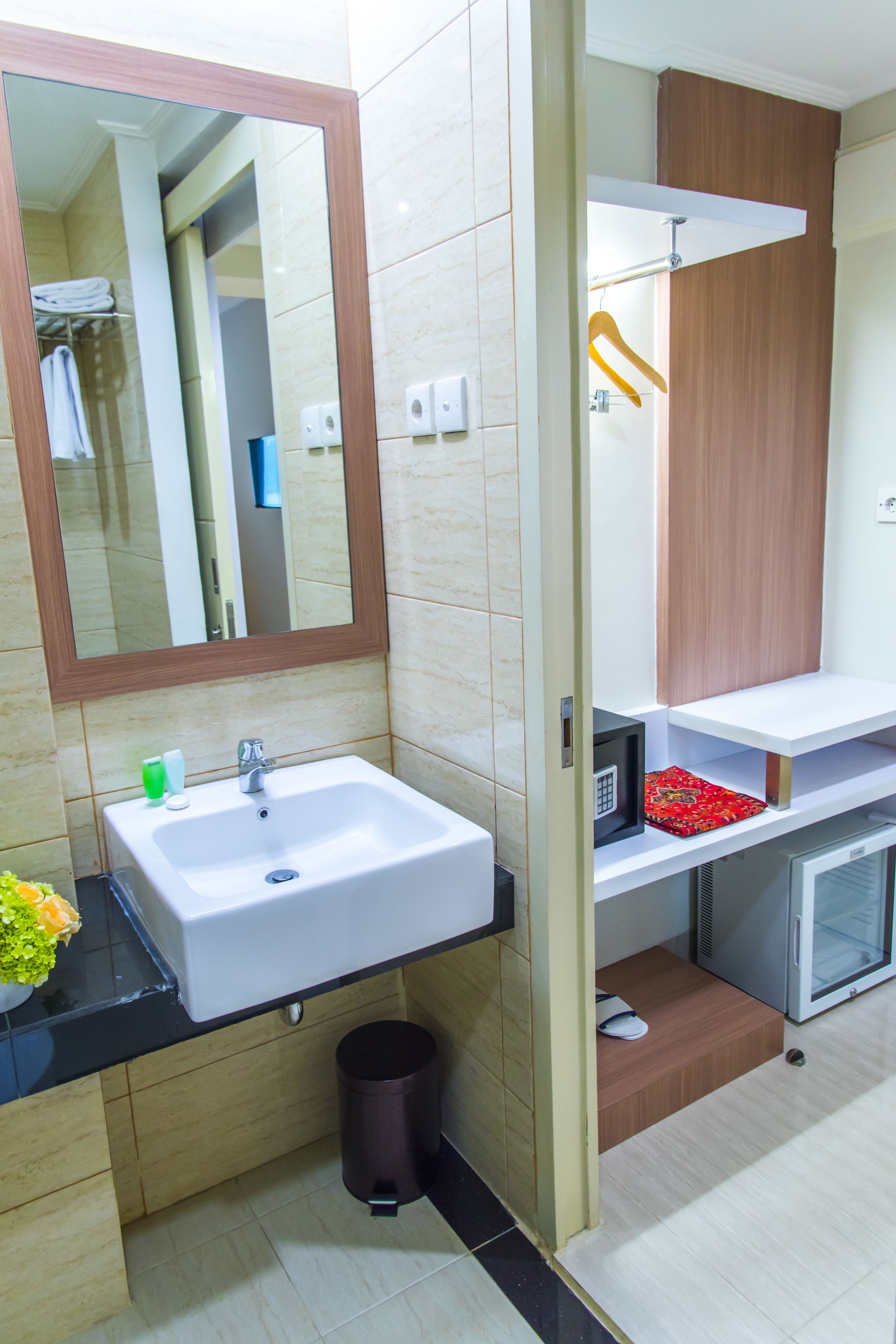 A bathroom with a white sink, mirror, and wooden vanity.