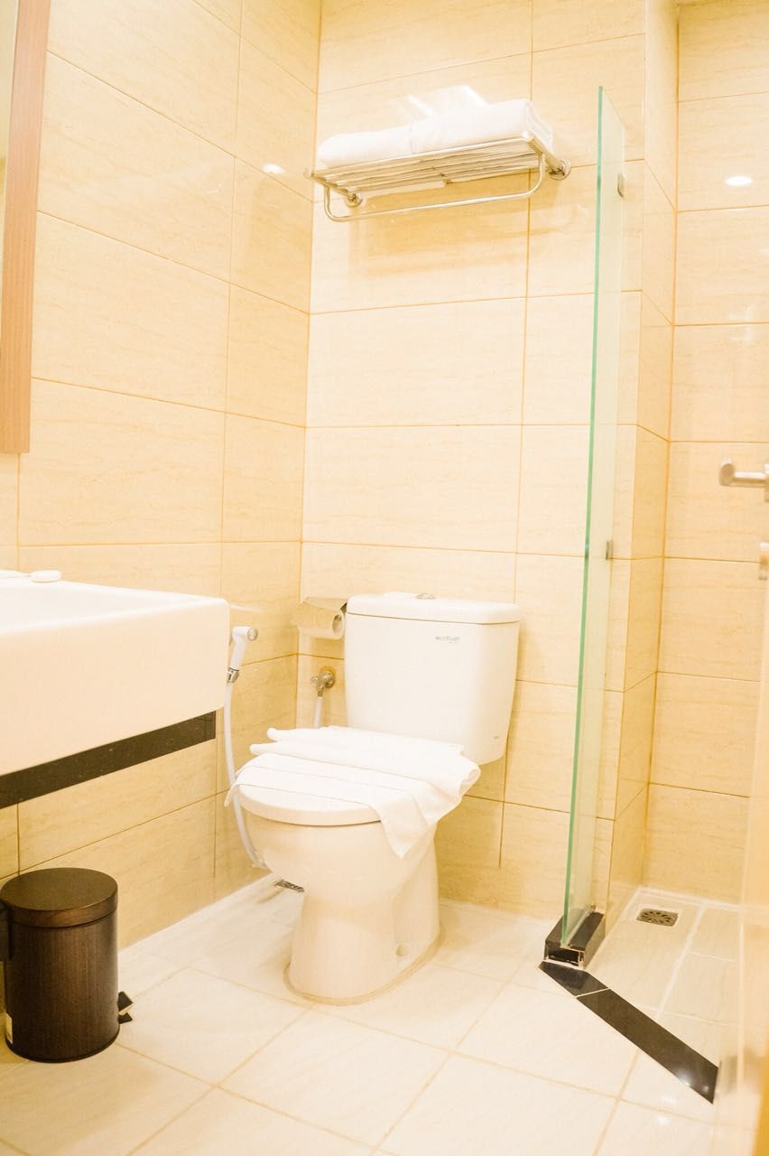 A bathroom with a toilet, a sink, and a glass shower enclosure.