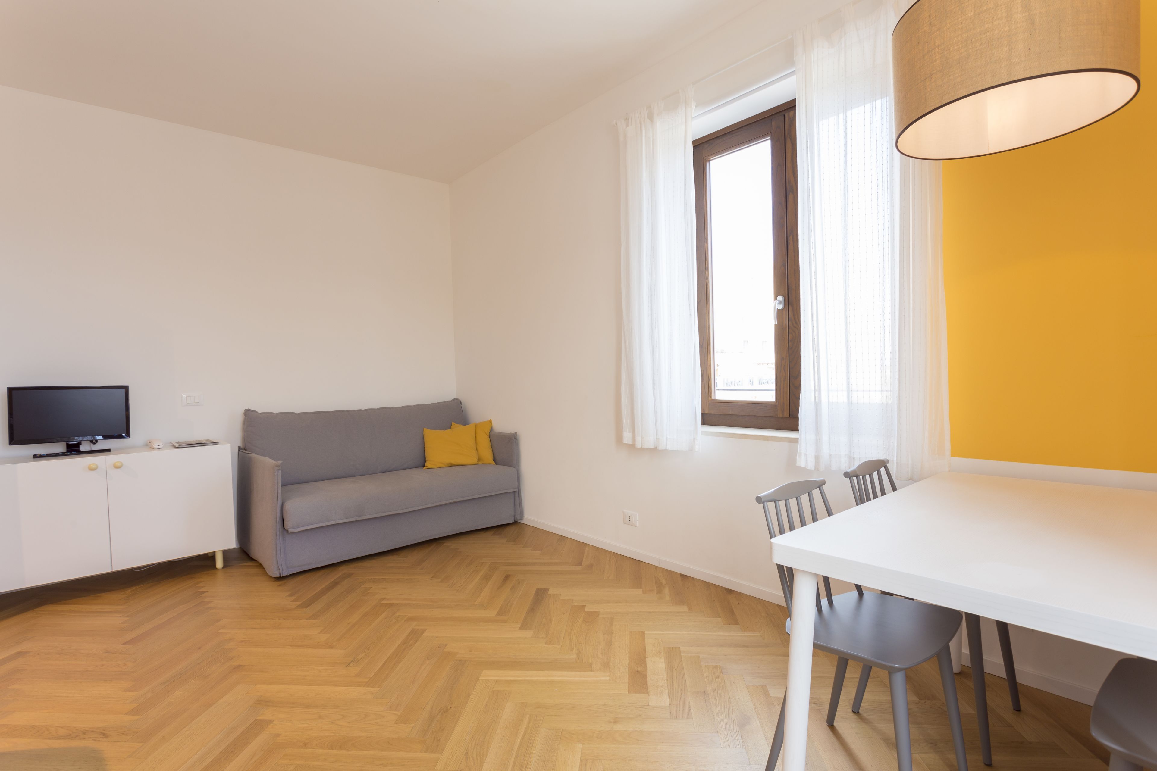 Un salon moderne avec un canapé, une table à manger et un téléviseur.
