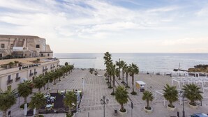A coastal hotel with a terrace, palm trees, and a view of the sea. - Residence ITACA (Castellammare del Golfo)