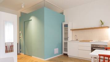 Eine moderne Küche mit weißen Schränken, einer Holz Arbeitsplatte und einem eingebauten Ofen.