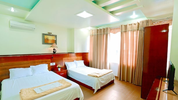 A hotel room with two beds, a TV, and a red desk. - Daiichi Cat Ba Hotel (Hai Phong)