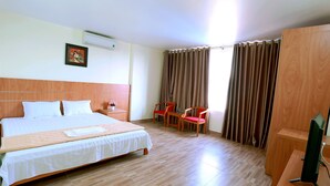 A hotel room with a large bed, a desk with a computer, a chair, and a TV. - Daiichi Cat Ba Hotel (Hai Phong)