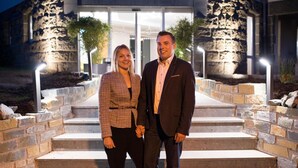 A couple standing on stone steps in front of a building with a stone facade and glass entrance. - Hotel am Herkules - garni (Kassel)
