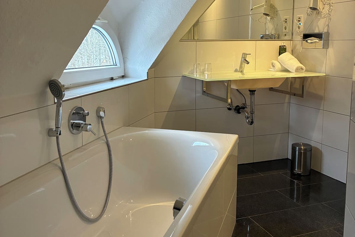 Suite | Badkamer | Een diep bad, een haardroger, handdoeken