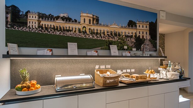A buffet setup with a variety of food items and a decorative backdrop of a classical building. - Biohotel Wilhelmshöher Tor (Kassel)