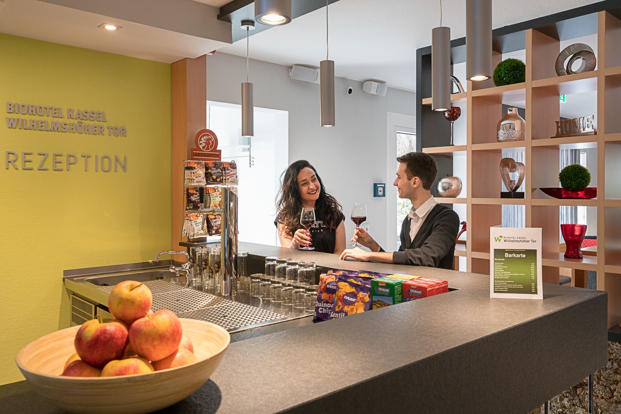 Zona de recepción con barra, un frutero de manzanas y un panel con la carta.