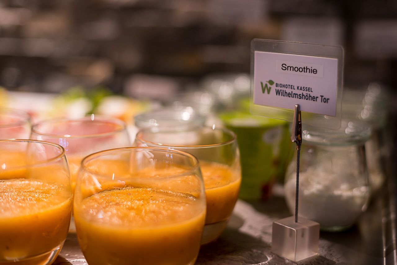 A selection of smoothies on a table with a sign indicating the location.