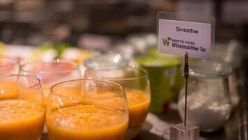 A selection of smoothies on a table with a sign indicating the location.