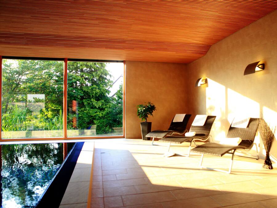 Una piscina techada, sillones reclinables de piscina