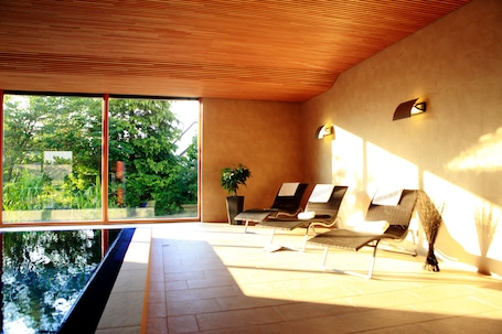 Una piscina techada, sillones reclinables de piscina