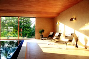 Una piscina techada, sillones reclinables de piscina