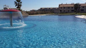 Una piscina con fuente, rodeada de edificios.
