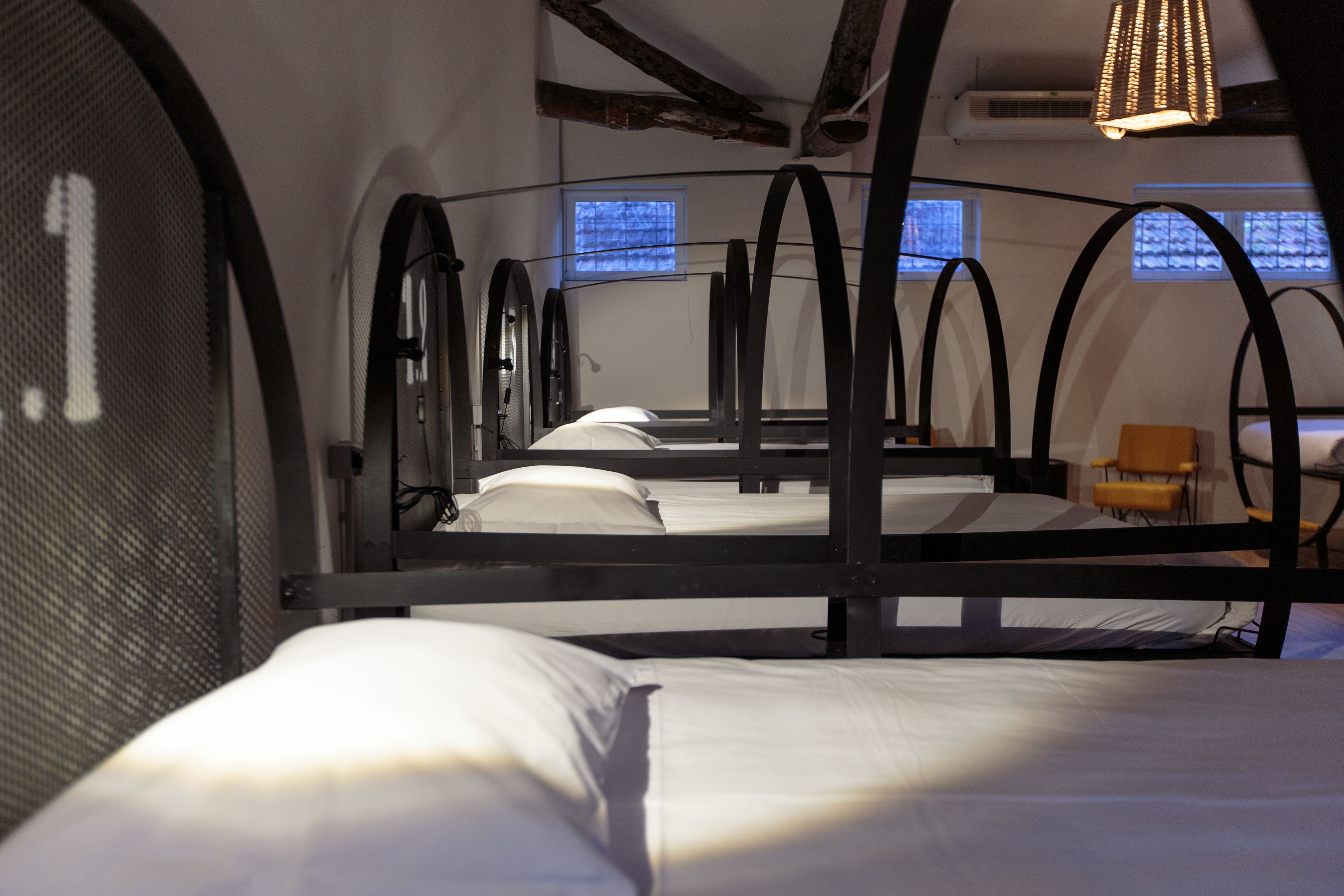 A room with bunk beds, a small table, and a chair.