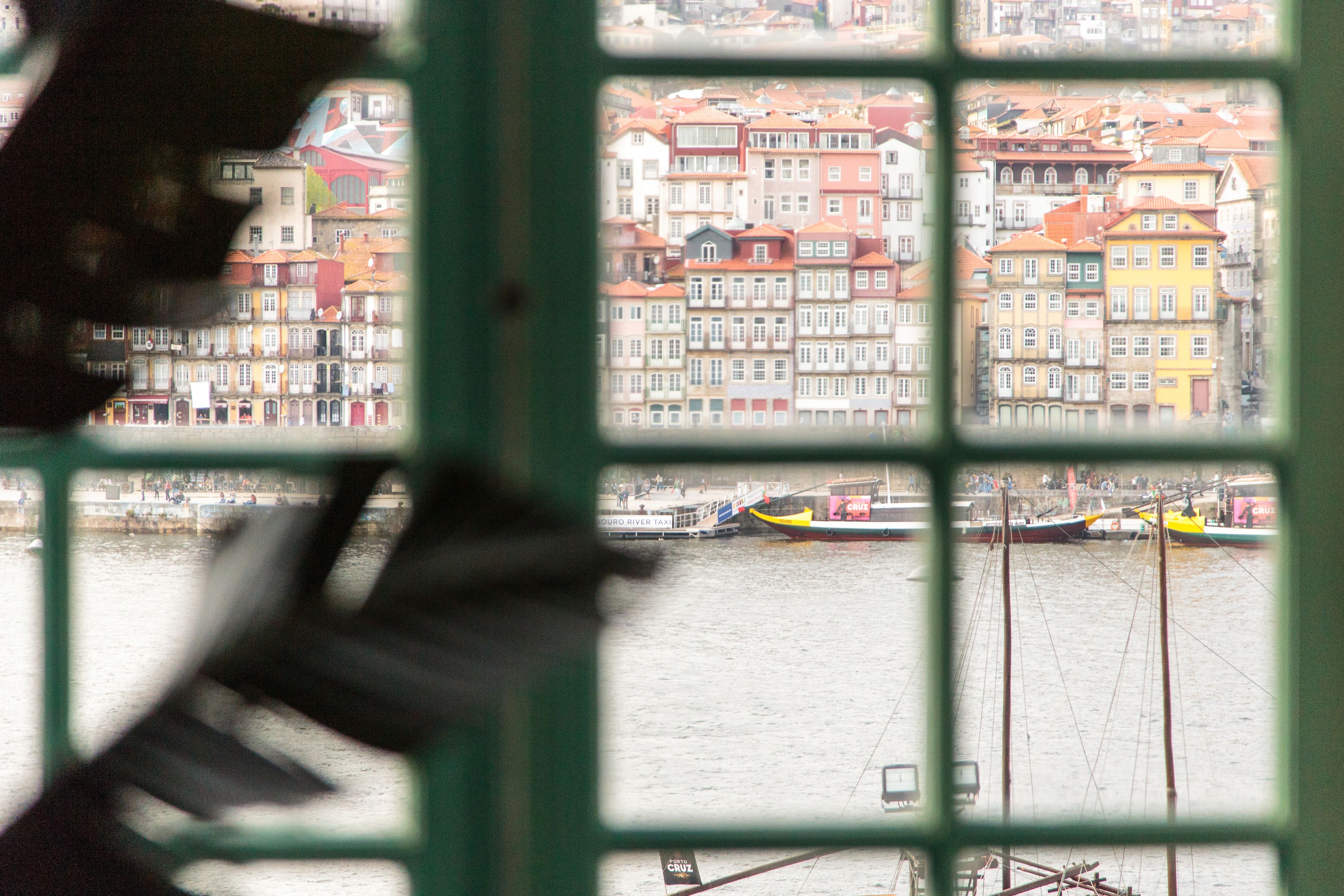 Une vue sur une rivière, avec des bateaux et des bâtiments aux couleurs vives en arrière-plan.
