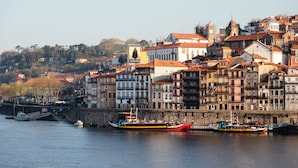 Una zona histórica frente al río, con edificios tradicionales y barcos amarrados.