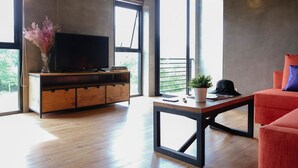 Una sala de estar moderna con un aparador de madera, un televisor de pantalla plana, un sofá rojo y una mesa de centro.