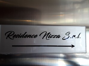 A sign with the text "Residence Pizza S.r.l." and an arrow pointing to the right.