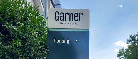 A sign for Garnier IHG Hotel with a direction to parking.