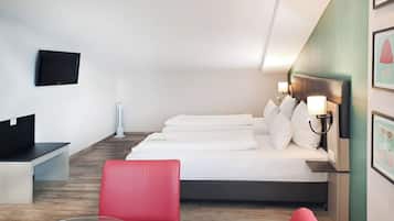 Una camera d'albergo con un letto, una scrivania, una sedia e una televisione.
