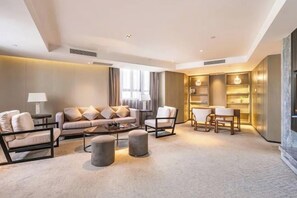 Una sala de estar moderna con un sofá, sillones, una mesa de centro y una chimenea.