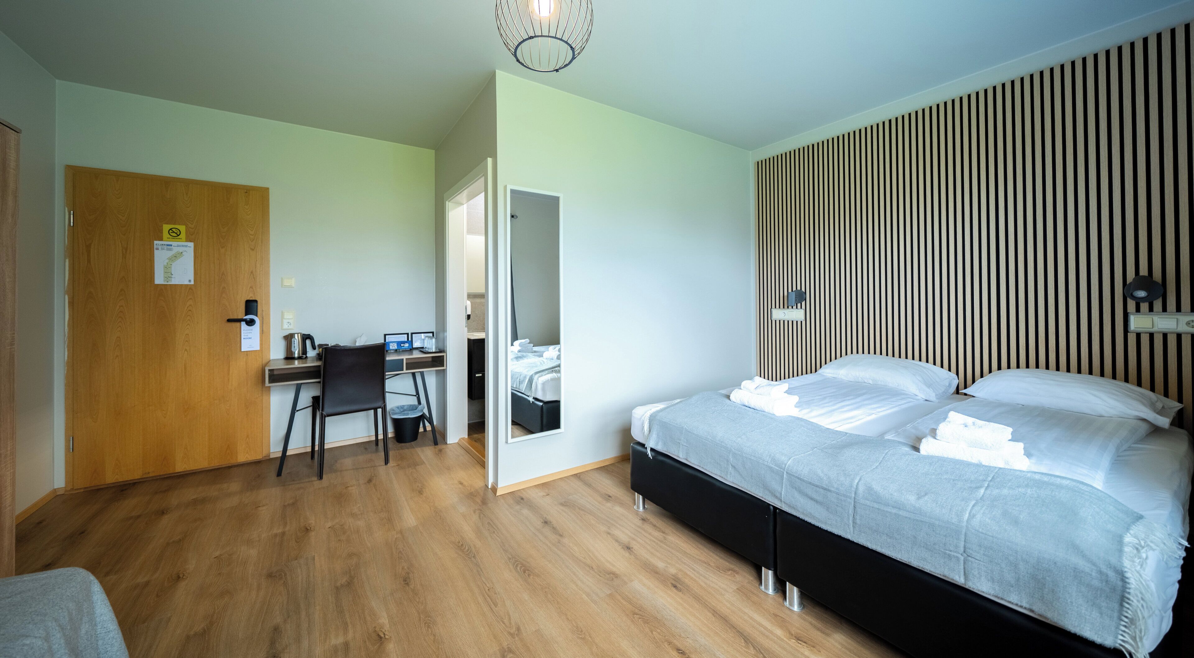 A bedroom with a bed, a desk, and a chair.