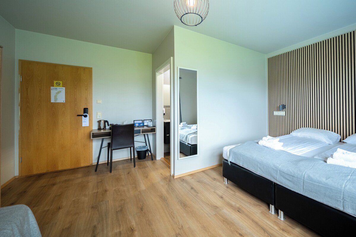 Quarto com cama, escrivaninha e cadeira.