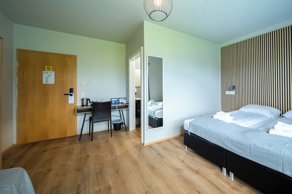 Un dormitorio con una cama, un escritorio y una silla.