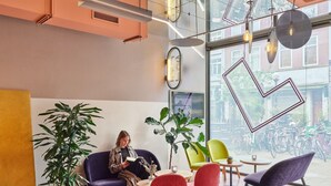 A modern interior with a seating area, large windows, and a view of bicycles outside. - CityHub Rotterdam (Rotterdam)