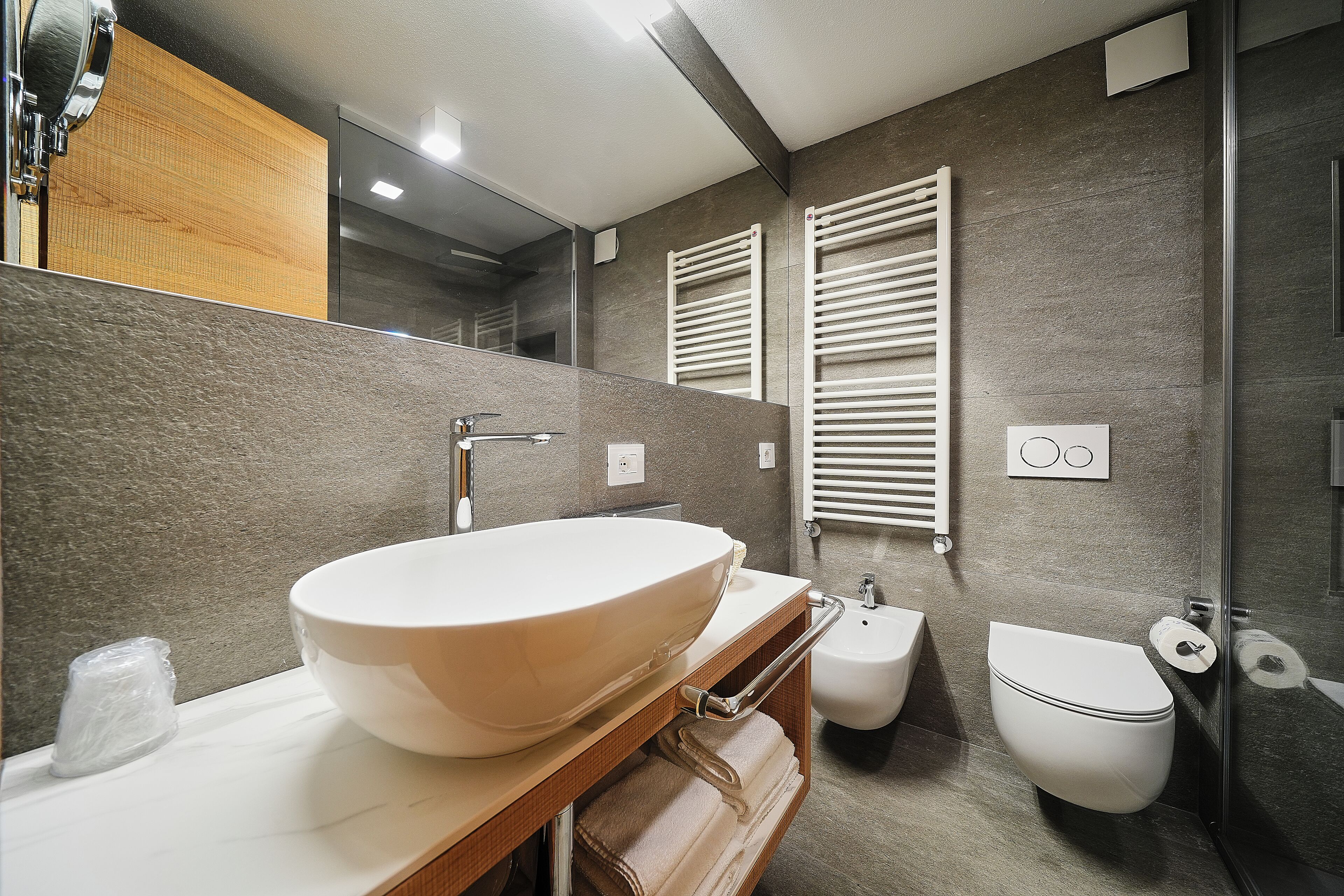 Ein modernes Badezimmer mit einem großzügigen Aufsatzwaschbecken, einem Bidet und einer Toilette.