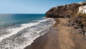 Una spiaggia costiera con scogliere rocciose e edifici sulla cima.