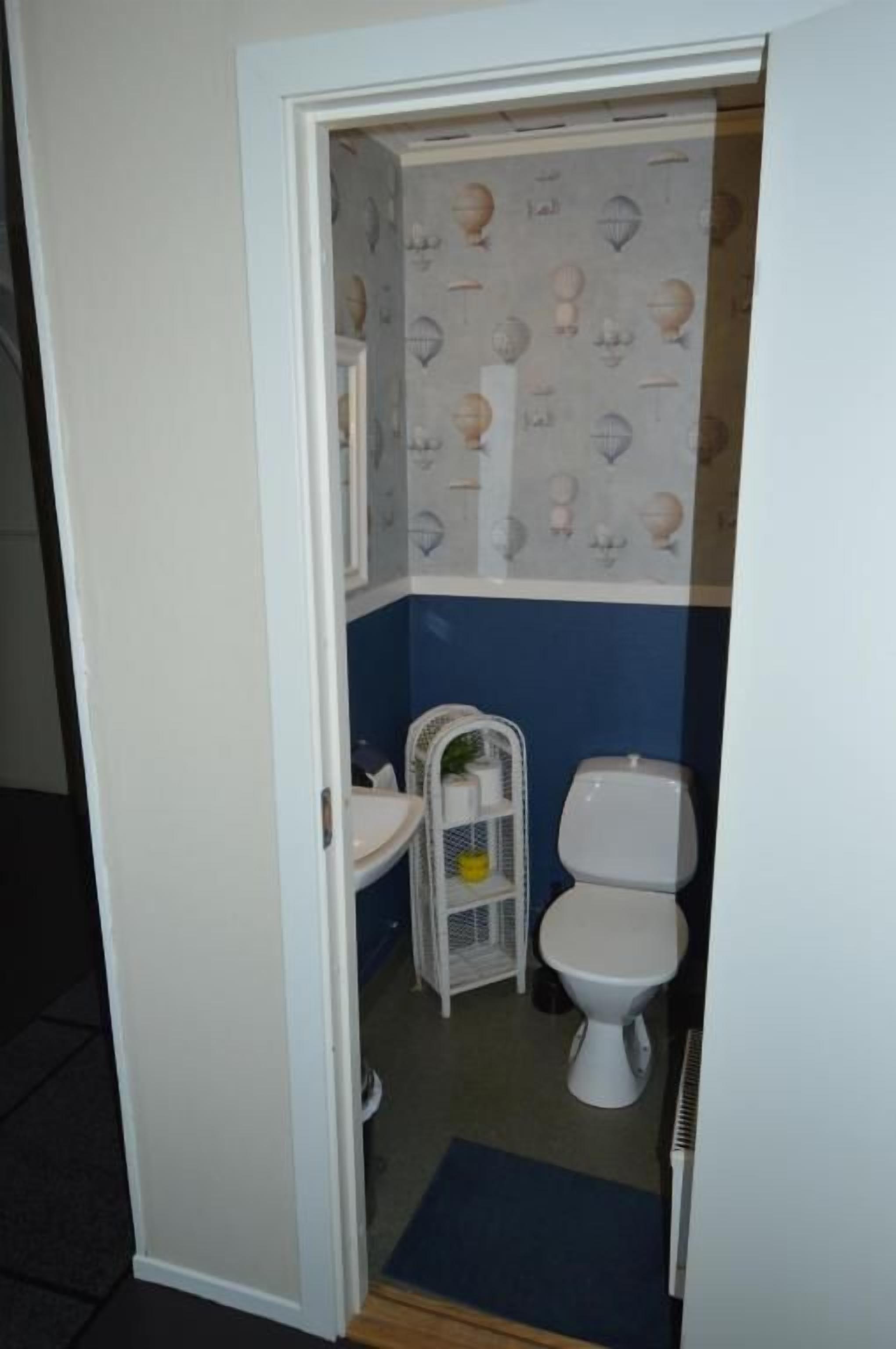 A small bathroom with a toilet, sink, and a shower area.
