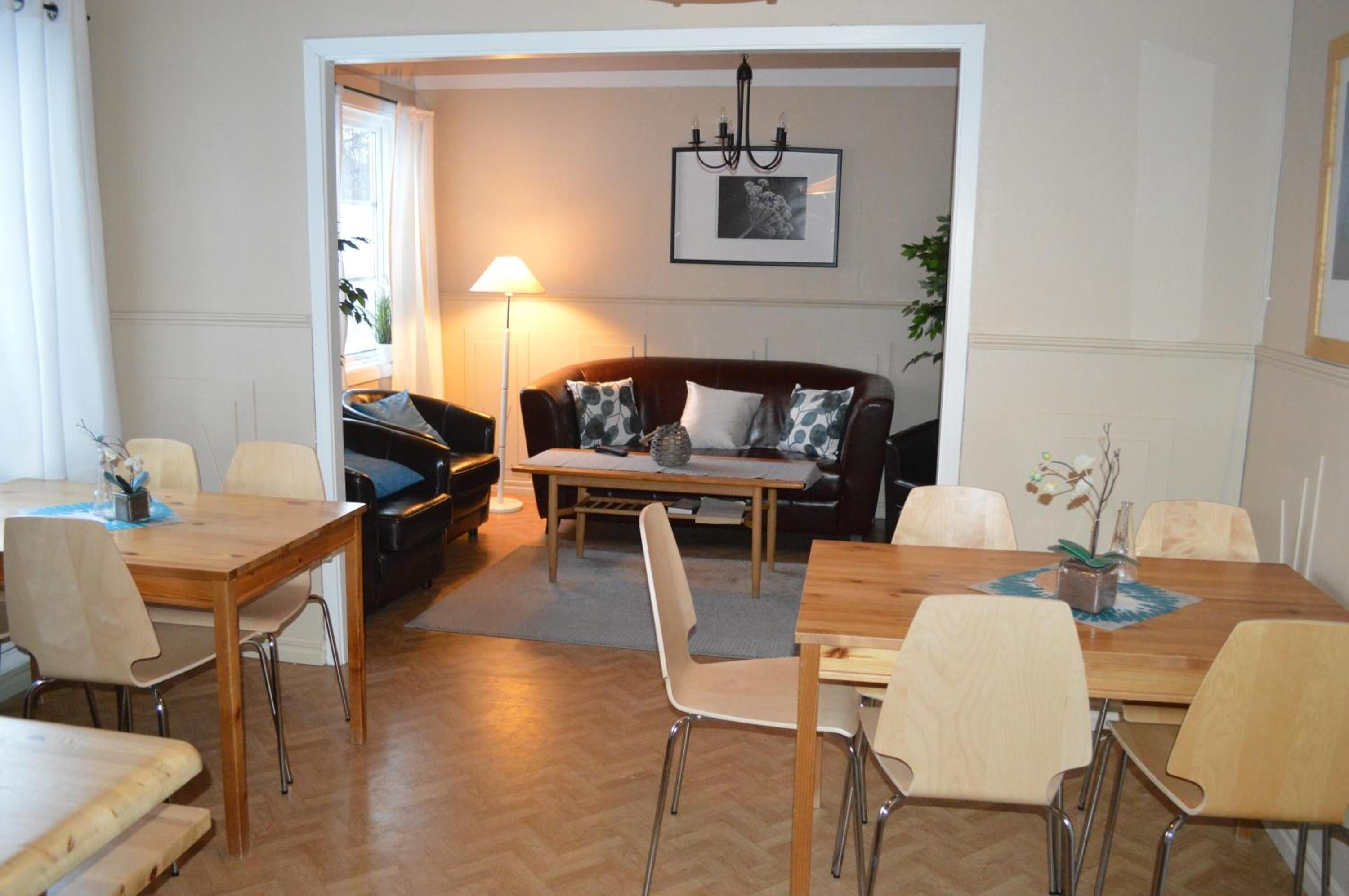 En matplats med ett träbord och stolar, en soffa med mönstrade kuddar och en lampa.