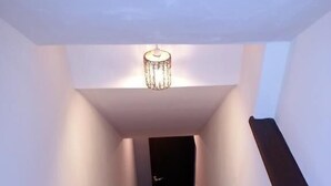 Una escalera con barandilla de madera y una lámpara en la parte superior.