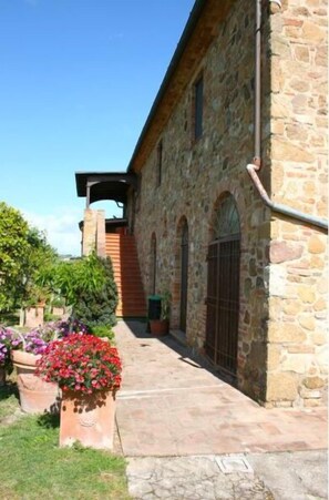 A stone building with a wooden staircase, a metal gate, and potted plants. - Stunning private villa with private pool, WIFI, TV, pets allowed and parking, close to Montepulc (Torrita di Siena)