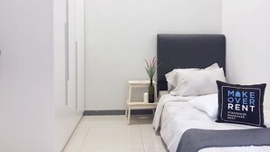 A modern bedroom with a bed, a bedside table, and a nightstand. - Gombak126 HomeStay (Kuala Lumpur)