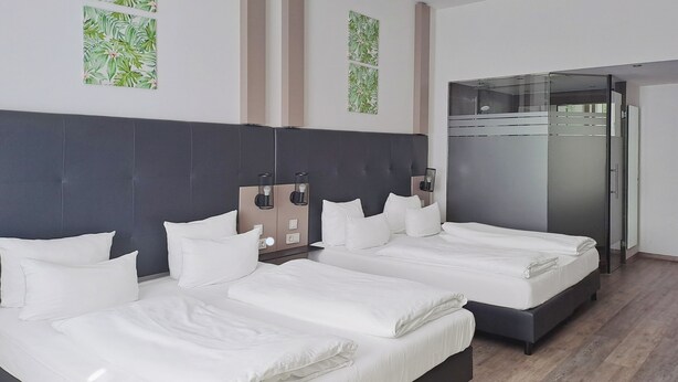 Habitación de hotel con dos camas, un armario y decoración en las paredes.