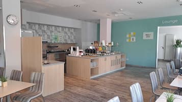 Un espace de détente moderne avec un bar, des sièges et une horloge au mur.