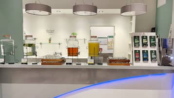 A beverage station with various drink dispensers and a refrigerator stocked with products.