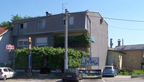 Un edificio de varios pisos con balcones, un cartel que dice 'Ivac' y un letrero de 'SuperSport'.