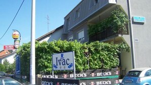 A building with a sign for 'Ivac' and multiple 'Beck's' banners. - Guesthouse Ivac Inn Zagreb Airport (Velika Gorica)