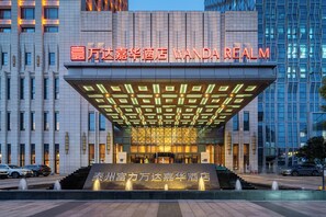 A hotel entrance with a modern design, featuring a prominent sign and a decorative facade. - Wanda Realm Taizhou (Taizhou)