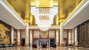 A spacious lobby with a large chandelier, marble flooring, and a decorative wall with a geometric pattern. - Wanda Realm Taizhou (Taizhou)