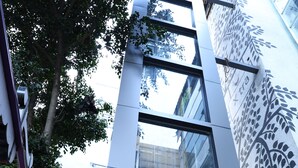 Un edificio moderno con fachada de vidrio y una escalera de metal.