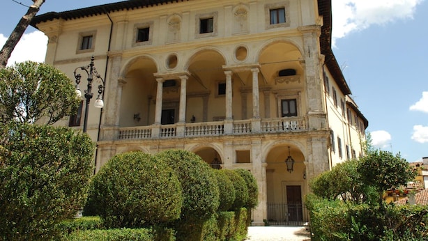 Um edifício histórico com pátio central, várias arcadas e varanda.